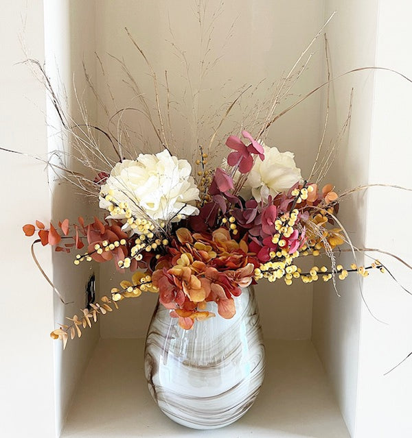Vase filled with dried  and silk flowers